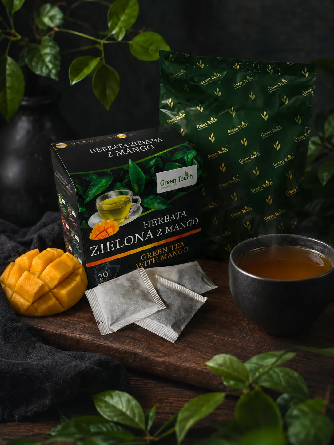 Green Touch Zielona z mango z workiem wewnętrznym, filiżanką i kawałkami mango.