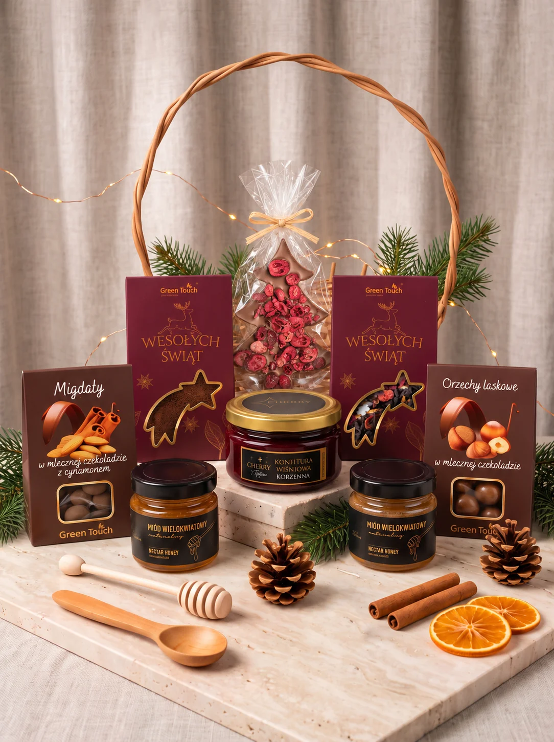 Świąteczny kosz prezentowy KR43_M z kawą, herbatą, miodami i czekoladową choinką — osiem produktów z choinką przed koszem, aranżacja pionowa
